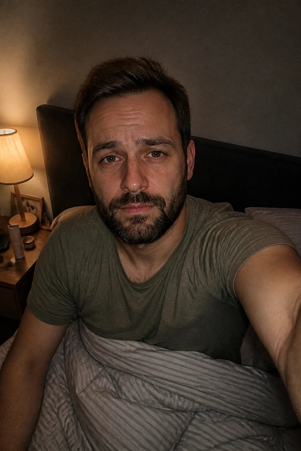 Selfie von Marc um 23 Uhr im Bett, nur die Nachttischlampe an, müder ehrlicher Blick