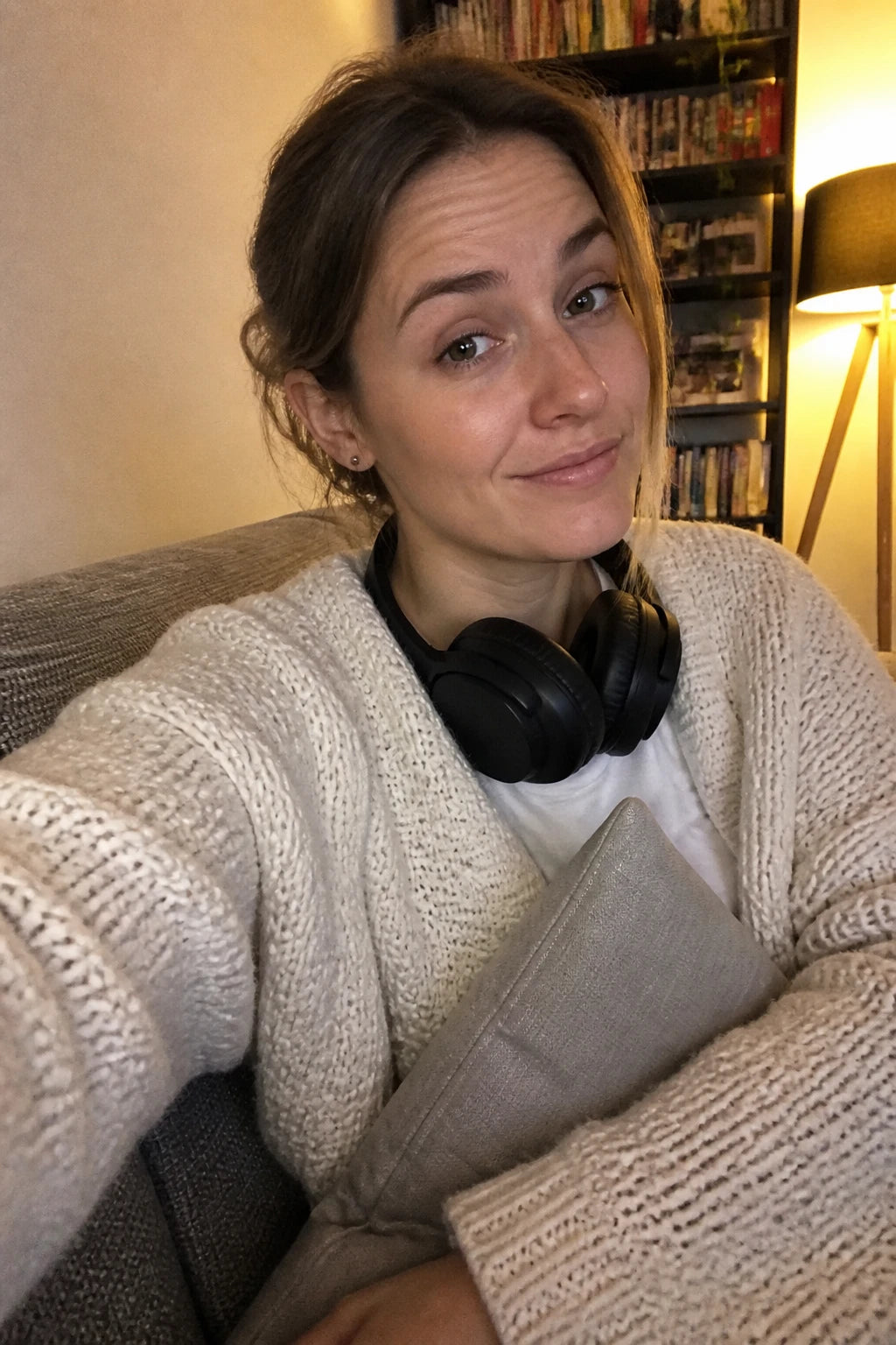 Frontkamera-Selfie der Autorin Lena in Woche 1: auf dem Sofa, Kopfhörer um den Hals, skeptisch hochgezogene Augenbraue
